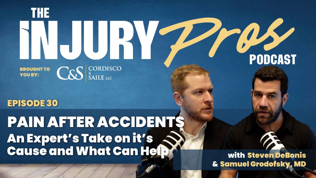 Two men sit in front of microphones on the set of "The Injury Pros Podcast" episode 30, discussing pain after accidents and expert advice on causes and treatments.